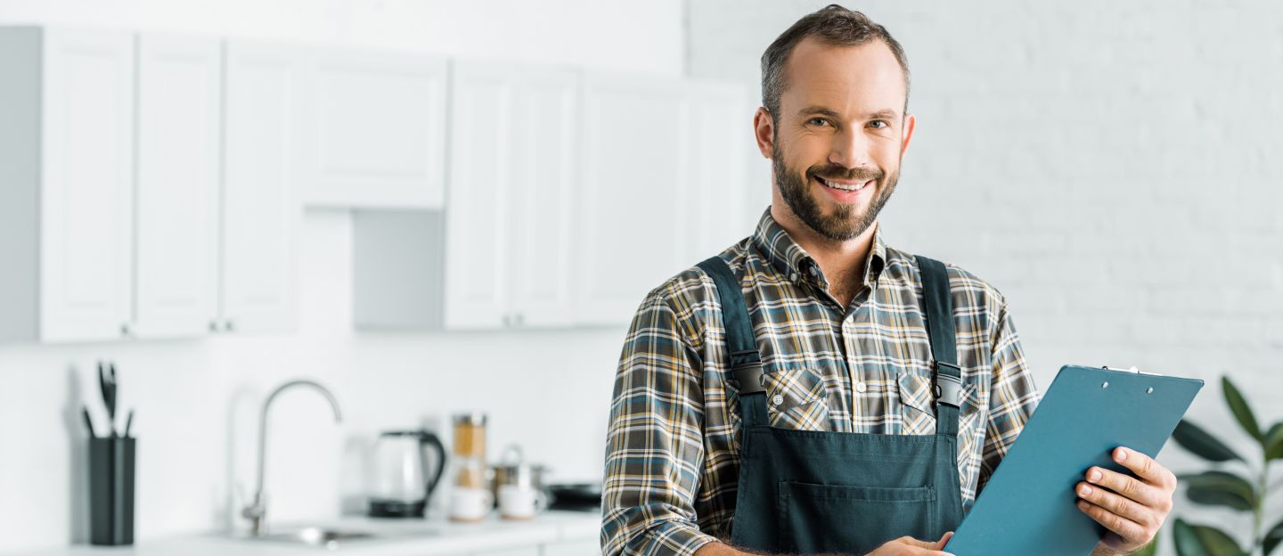 Smiling,Handsome,Plumber,Holding,Clipboard,And,Looking,At,Camera,In