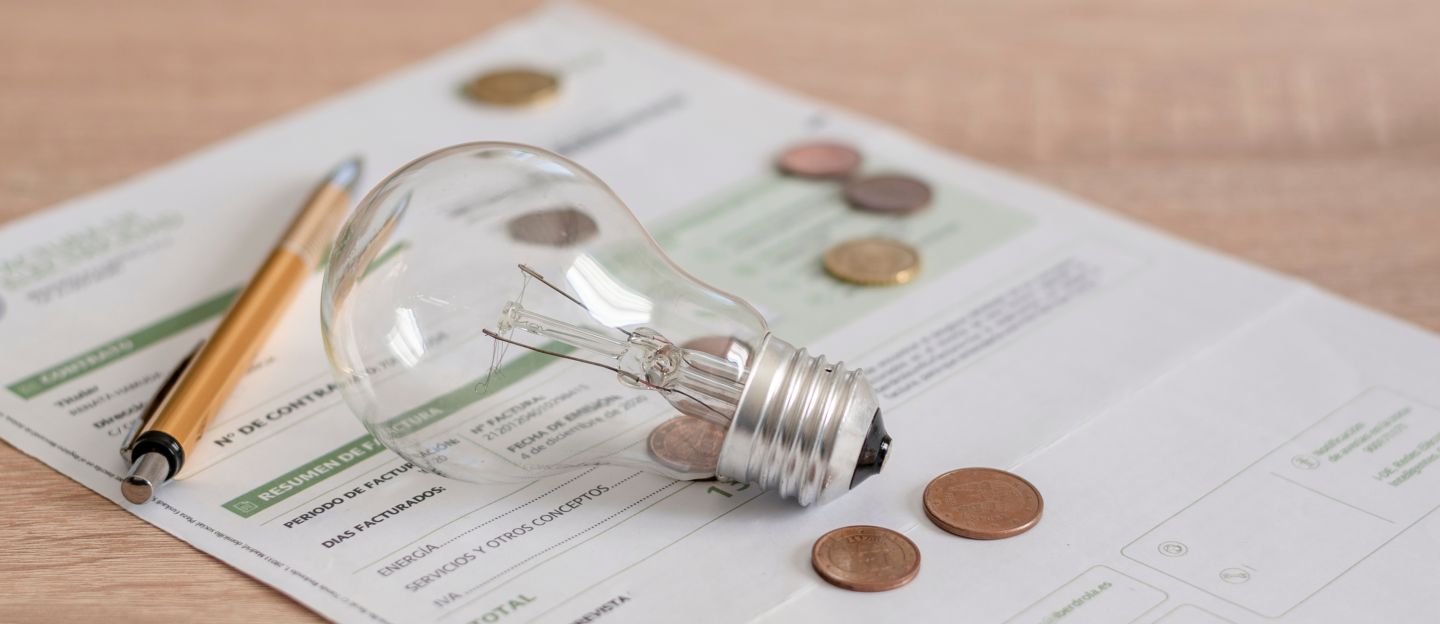 Electricity,Bill,With,Light,Bulb,,Several,Coins,And,Pen,On