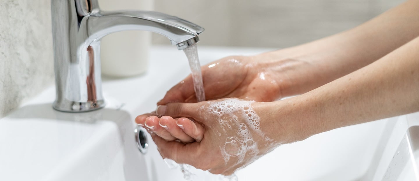 Woman washing her hands in sink at bathroom