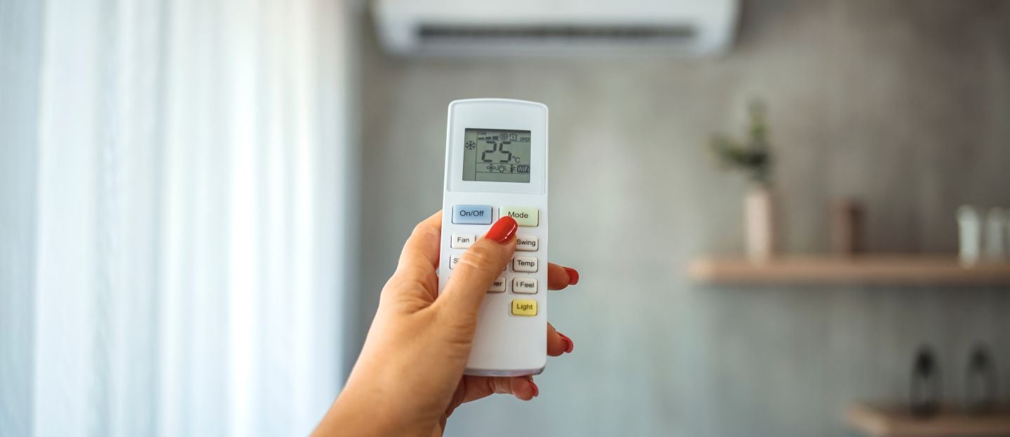 Air,Conditioner,Inside,The,Room,With,Woman,Operating,Remote,Controller.