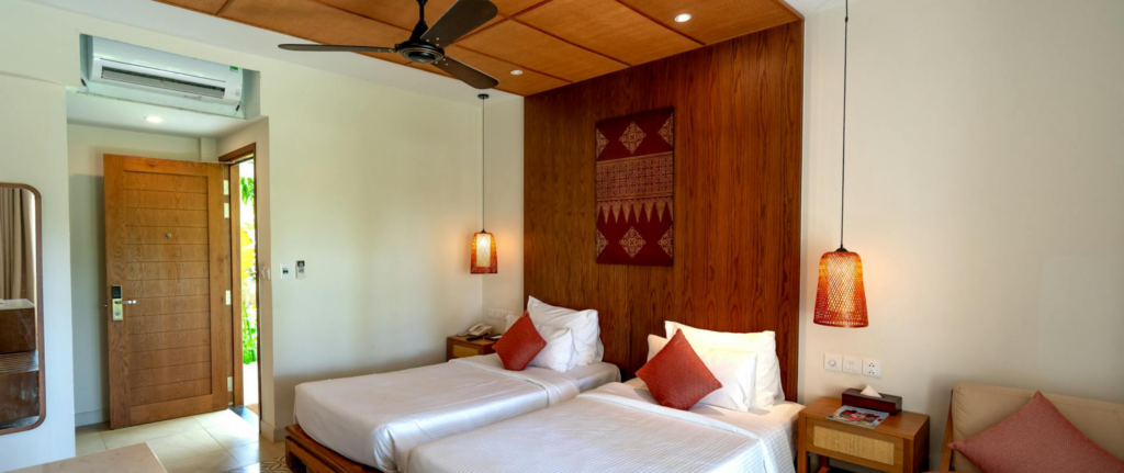 kamar ber-ac yang cozy dengan ranjang twin 