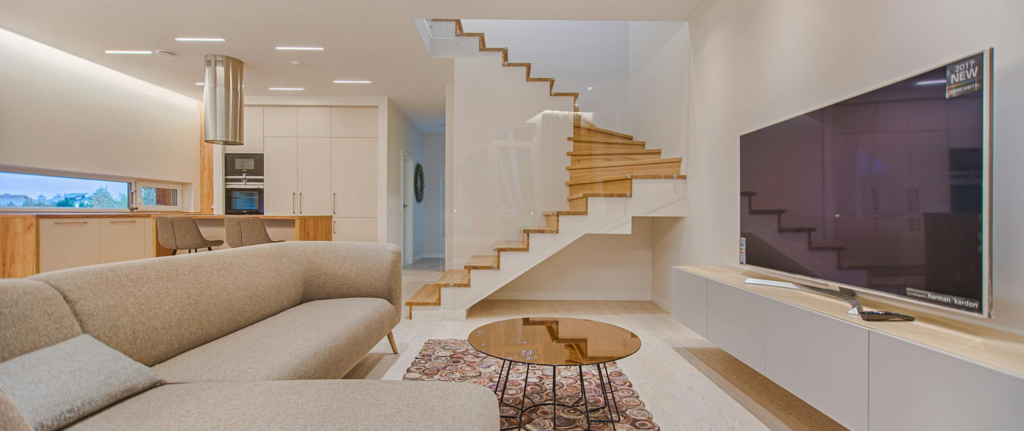 ruang tamu bernuansa coklat dan krem dengan tv besar