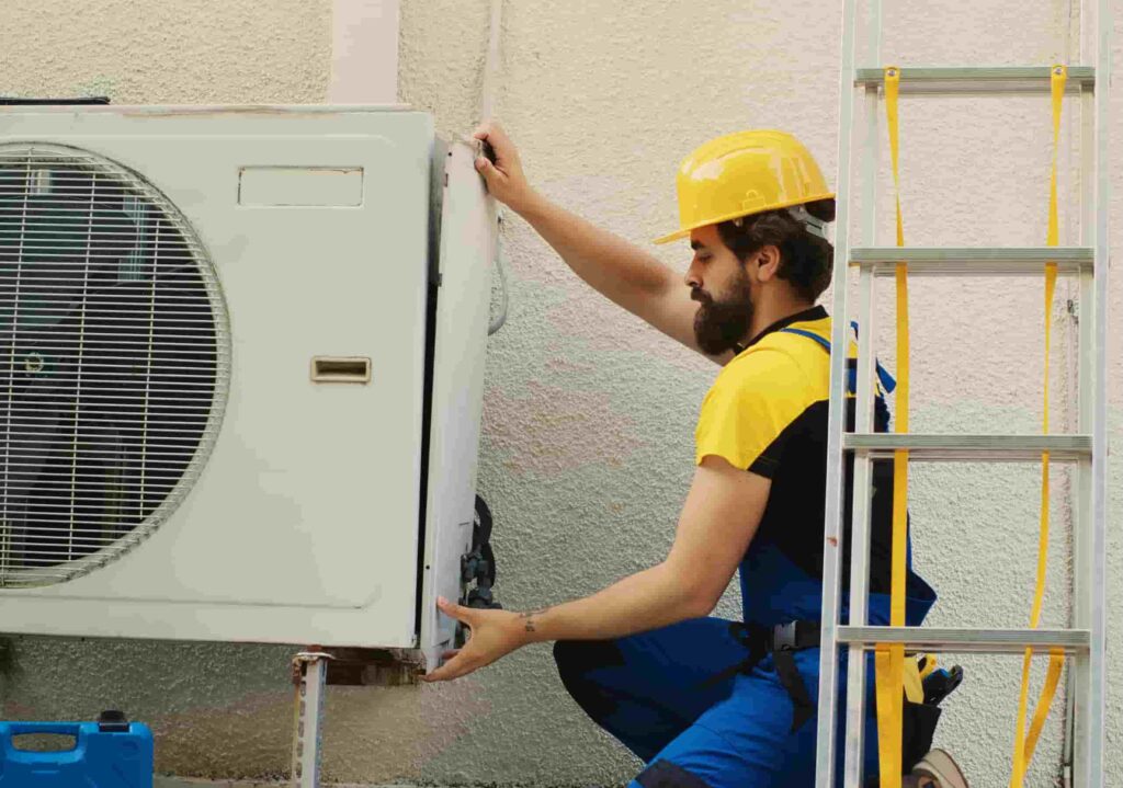 orang yang memasang heat pump outdoor di luar rumah