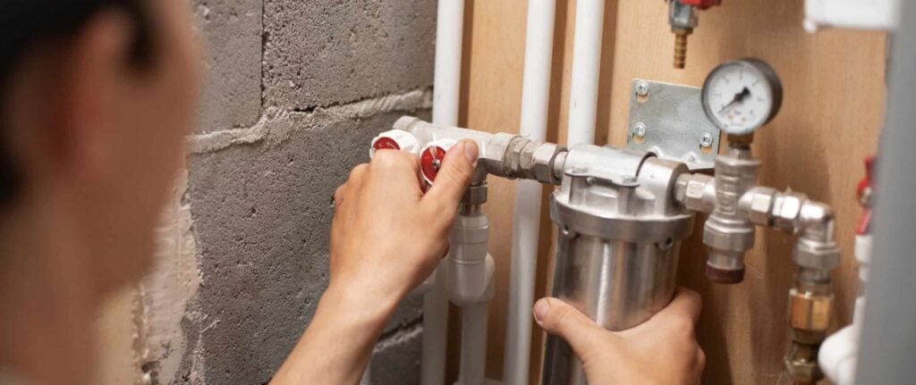 orang yang sedang memeriksa pipa water heater