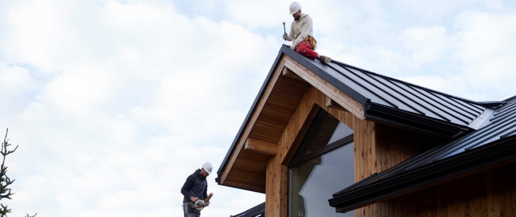 dua pekerja menggunakan safety sedang bekerja di atap rumah