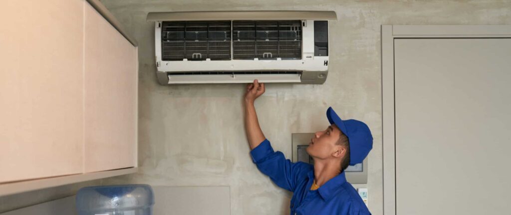 seorang teknisi sedang memeriksa unit indoor ac