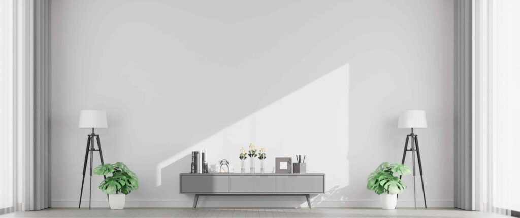 ruangan berdinding light grey dengan lampu, nakas, tanaman, dan gorden