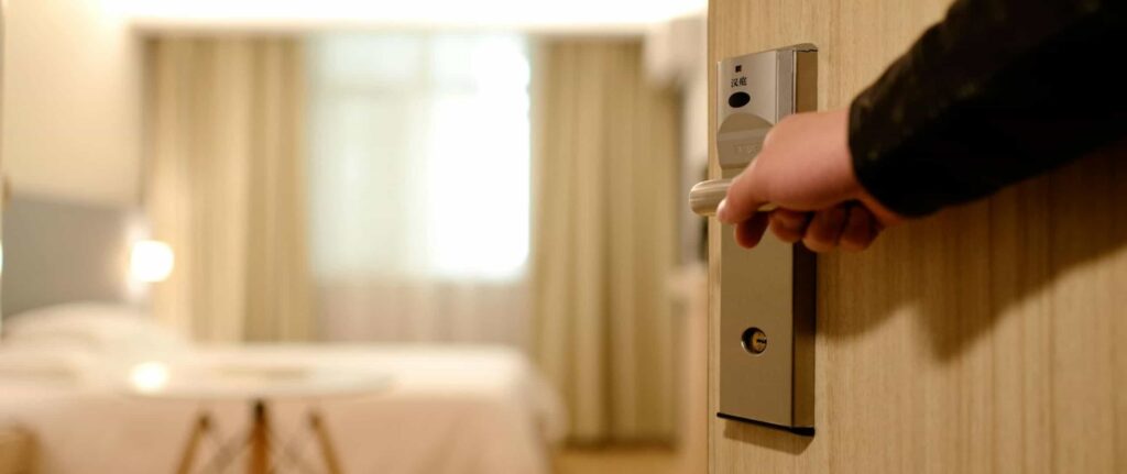 seseorang memegang tuas pintu kamar 