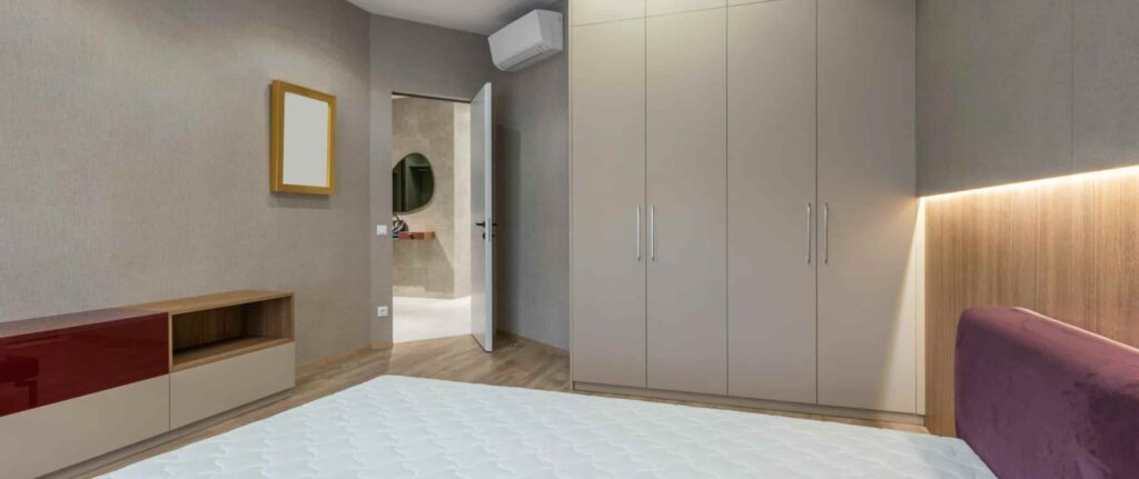 kamar tidur ber-ac warna abu-abu dan aksen kayu