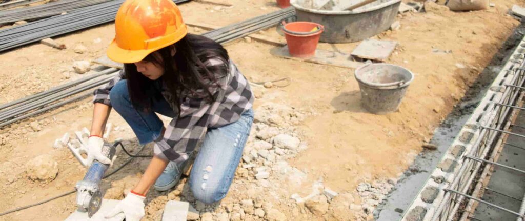 pekerja wanita sedang memotong material dengan gerinda