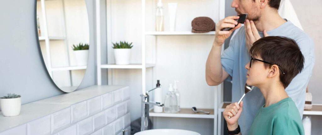 ayah dan anak sedang menggunakan alat cukur di kamar mandi ayah dan anak sedang menggunakan alat cukur di kamar mandi