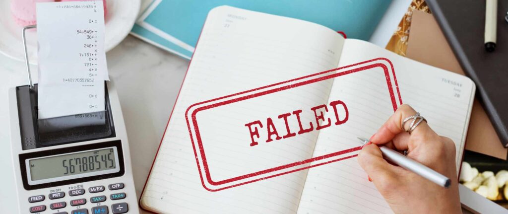 kalkulator dan buku yang bertuliskan “failed”