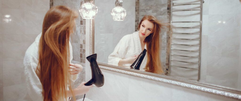 wanita sedang memakai hair dryer di kamar mandi wanita sedang memakai hair dryer di kamar mandi