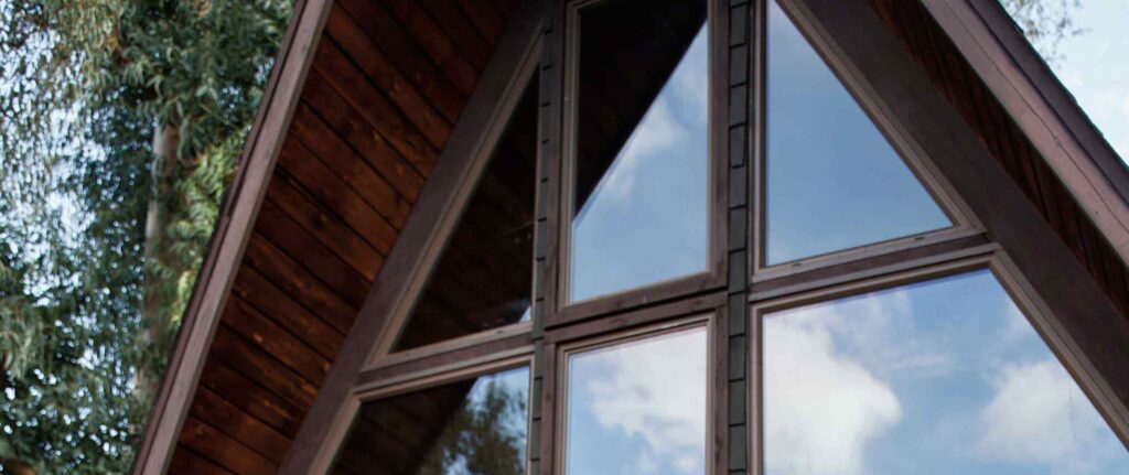 rumah kayu dengan atap miring dan jendela kaca penuh