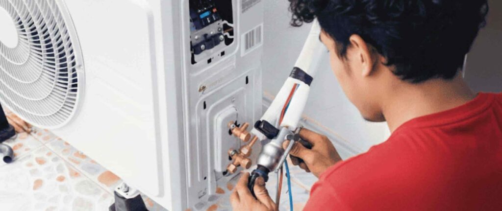 Seorang pria sedang melakukan pengecekan kebocoran freon