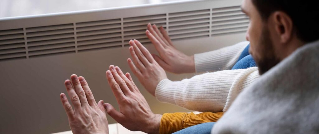 orang yang mengecek temperatur heat pump dengan telapak tangan