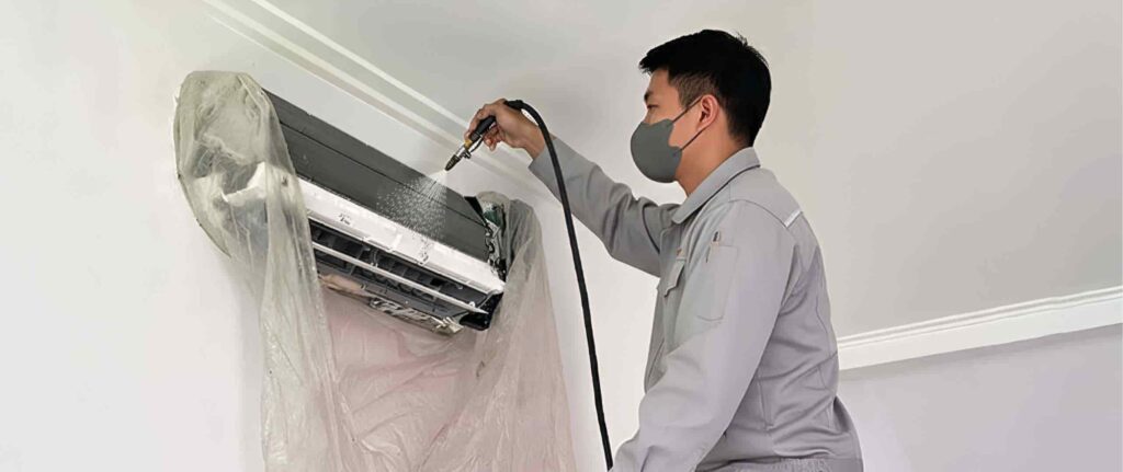 Seorang pria sedang mencuci AC