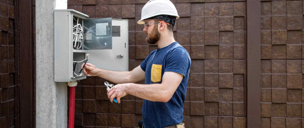 seorang teknisi memeriksa instalasi kabel listrik